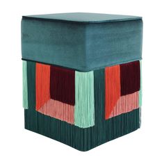 a square box with fringes on the sides and an orange, red, green, and blue design