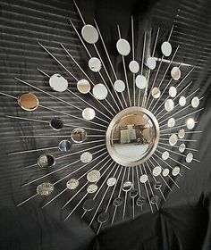 a mirror that is sitting on top of a black cloth with lots of different objects in it