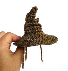 a hand holding a small knitted hat