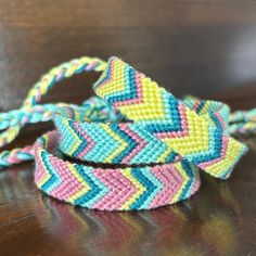 two colorful bracelets sitting on top of a wooden table