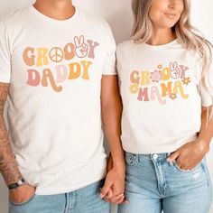 two people standing next to each other wearing t - shirts that say grooy daddy and groo mama