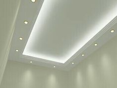 an empty room with white walls and lights on the ceiling is pictured in this image