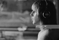 a woman with headphones on looking out the window at something in the distance stock photo