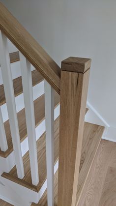 a wooden banister with white handrails and wood flooring