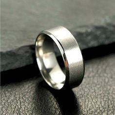 a wedding ring sitting on top of a piece of leather next to a black cloth