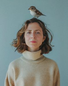 a woman wearing a turtle neck sweater with a bird on her head above her head