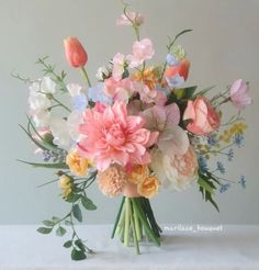 a vase filled with lots of different colored flowers