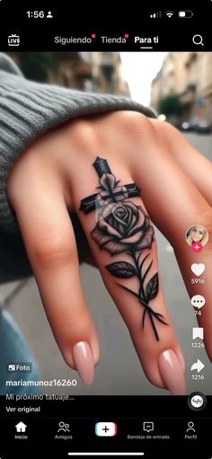 a person's hand with a rose tattoo on it