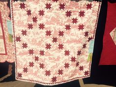 two red and white quilts hanging on a clothes line