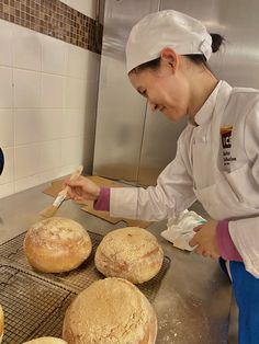 a woman in a kitchen preparing bread rolls