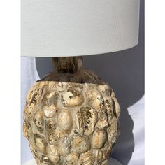 a lamp that is sitting on top of a white base with a light shade over it