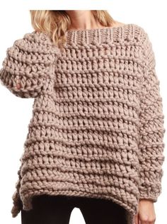 a woman is wearing a sweater made out of chunky knits