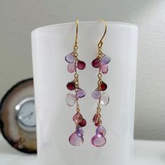 Our iconic earrings are now composed of mystic pink topaz, mystic pink quartz, garnet, rhodolite garnet and light amethyst gemstones. The largest gem measures approximately 10 mm across. These earrings resemble a previous pair with slightly different nuances. This set has a simple profile and measures a little longer than the previous rendition. These earrings are finished in gold vermeil and completed with simple ball-end earwires. Earrings measure approximately 2¼-inches from the bottom of the earwire. Handmade by me in San Francisco, CA, USA. Item ships in a leatherette jewelry box with Blue Easel Designs logo via USPS Priority Mail with Delivery Confirmation and shipping insurance. Find more designs at www.blueeaseldesigns.com Tourmaline Multi-stone Earrings As Gift, Tourmaline Multi-stone Earrings For Gift, Multi-stone Tourmaline Earrings As A Gift, Pink Amethyst Gemstones As A Gift, Amethyst Multi-stone Earrings As Gift, Amethyst Multi-stone Briolette Earrings, Simple Profile, Cluster Jewelry, Light Amethyst