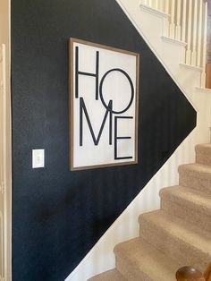 the stairs are painted black and white with a home sign on it's wall