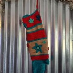 a crocheted christmas stocking hanging on a metal wall