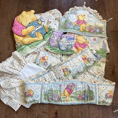 winnie the pooh baby bedding set with matching blanket and diaper covers on wooden floor