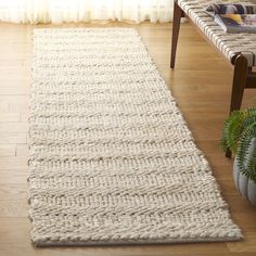 a large white rug on top of a wooden floor