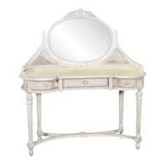 a white vanity with a mirror on top of it