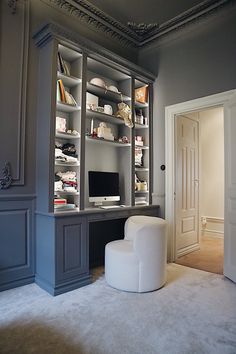 a home office with built in bookshelves and shelving