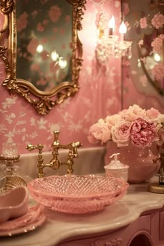 a fancy bathroom with pink flowers and gold accents on the vanity, mirror and sink