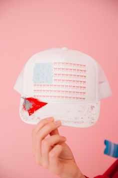 Get patriotic pizzazz with our BOW FLAG WHITE TRUCKER HAT! This adjustable back hat features a bold bow American flag design with sparkly silver glitter. The red and silver feather combo adds the perfect finishing touch. Perfect for any summer celebration! This is a made-to-order item. All customized orders are currently shipping within 14 business days. To receive item quicker, expedited shipping is available at checkout. Patriotic White Snapback Trucker Hat, Patriotic White Trucker Hat, Patriotic White Trucker Hat/baseball Cap, Patriotic White Hat For Summer, White Baseball Cap Trucker Hat For 4th Of July, Patriotic White Trucker Hat With Curved Brim, White Snapback Party Hat, White Snapback Hat For Party, White Trucker/basbeall Cap For 4th Of July