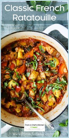 a large pot filled with stew and vegetables on top of a blue cloth next to a spoon