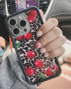 a woman is holding up her phone case with apples and leopard print on the cover