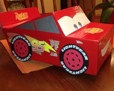 a cardboard race car sitting on top of a wooden table