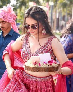 a woman in a pink dress carrying a cake