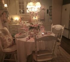 a dining room table is set with flowers and candles