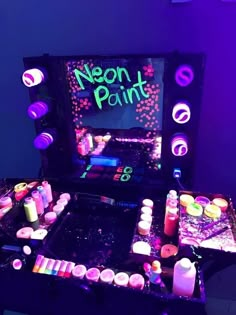 a neon pinball machine with candles and other items on the table in front of it