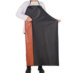 a woman in an apron holding up a black and orange apron