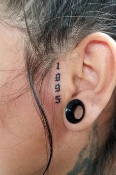 a woman with black ink on her ear has the word i love you written in it