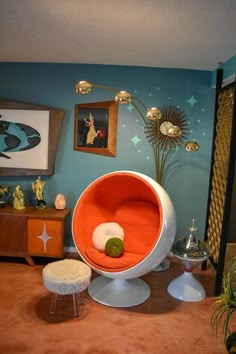 an orange and white chair sitting on top of a wooden floor next to a table