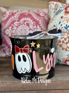 a black bucket with a red bow on it and the word lolly painted on it