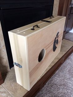 a wooden box sitting in front of a fireplace