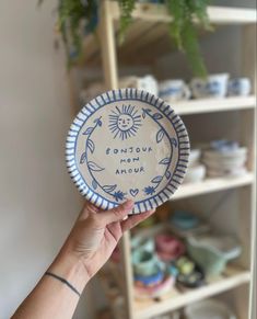 a person holding up a paper plate with the words fondous me amur on it