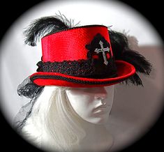 "This Gothic top hat is heavy red velvet wrapped with a black velvet and lace hatband and has a soft black crushed tulle bow & long tails in back. This Victorian style riding hat has black satin roses centered in the back.  There is a silver antiqued Celtic cross centered on a beautiful black lace applique on the front of the crown. A black lace applique rests on the back of the crown's top. The brim & crown edge are trimmed in black satin braid. This hat is loaded with black curled ostrich plumes and measures 23\".  All of the pieces you see in my shop are my original designs and carefully crafted for your pleasure... be sure to contact me for any special requests you may have! For a look at my complete Women's Hat Collection click on this link.... https://www.etsy.com/your/shops/Marcelle Fitted Top Hat With Short Brim For Costume Party, Fitted Wide Brim Top Hat For Halloween, Fitted Hat Bands For Costume Party, Red Fitted Hat For Costume, Red Fitted Top Hat For Winter, Wide Brim Fitted Top Hat For Halloween, Red Fitted Mini Hat For Costume Party, Gothic Top Hat With Short Brim For Halloween, Gothic Top Hat With Short Brim For Costume Party