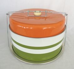 an orange, white and green striped cake tin