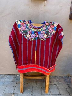 "Handwoven Vintage Guatemalan Blouse, Red Flower Patzun Huipil, Authentic & Traditional  Shoulders: 24\"  Length: 32\"  A woman may spend months weaving a single huipil when complex techniques or designs are required. Through the choices of design, material and finishing technique, information can be read about the weaver's birth-place, religious background, social position, weaving skill, and personality. Indigenous women can read the complex encoded messages in each other's huipiles at a glanc Red Long Sleeve Blouse With Floral Embroidery, Red Folk Style Top With Floral Print, Red Folk Style Tops For Festive Occasion, Traditional Red Blouse For Fall, Red Folk Blouse For Fall, Traditional Red Blouse For Spring, Red Vintage Tops With Floral Embroidery, Vintage Red Tops With Floral Embroidery, Red Long Sleeve Top For Festivals