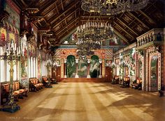 an ornate room with chandeliers and paintings on the walls