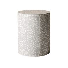 a white and grey vase sitting on top of a table