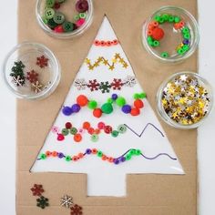 a paper bag with buttons and beads on it next to a christmas tree made out of cardboard