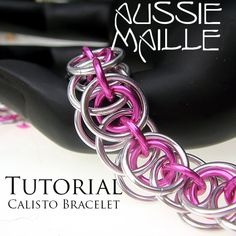 the chainmail bracelet is made with pink and silver metal wire, on top of a black object