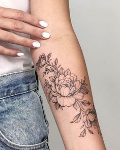 a woman's arm with a flower tattoo on the left side of her arm