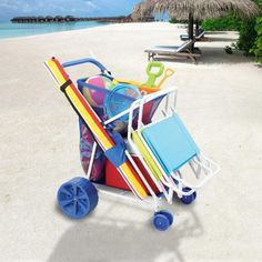 a beach cart filled with colorful items sitting on top of a sandy beach