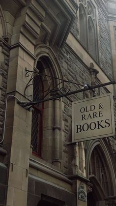 an old and rare books sign hanging from the side of a building