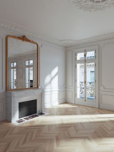 an empty living room with white walls and wood floors