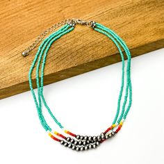 Three stranded necklace with mostly turquoise beads. This necklace also includes a segment of silver beads on each strand with a couple white, red, and orange beads on each side of the segment. This necklace is pictured partially on a block of wood on a white background. Jewelry Websites, Boutique Names, Boutique Instagram, Native American Necklace, Kay Jewelry, Giddy Up Glamour, Bead Sewing, Necklace Ideas, Beaded Tassel Earrings