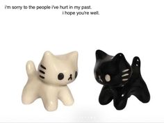 two black and white ceramic cats sitting next to each other